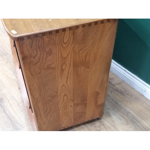 7 - An Ercol blonde elm Sideboard fitted three cupboard doors above two drawers raised on casters 4ft 3i... 