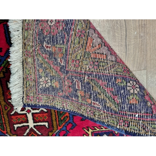 9 - A Persian style red ground woolen Runner within blue tramline border with stylised floral design 13f... 