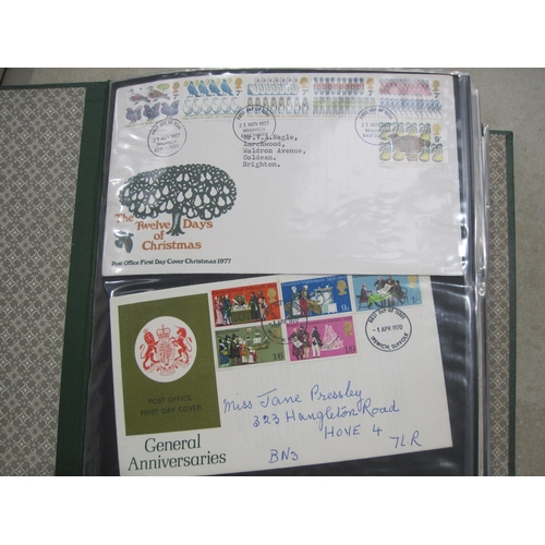 403A - An album containing approx 150 GB QE11 First day Covers; and some mint stamps in packs (qty)