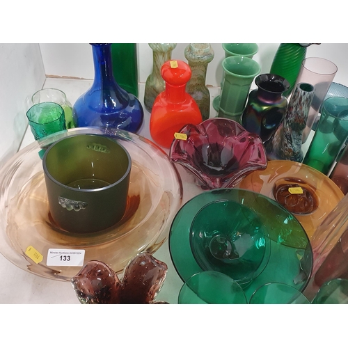 133 - A quantity of coloured glass including two overlaid Vases, green and amethyst Beakers, a tall green ... 