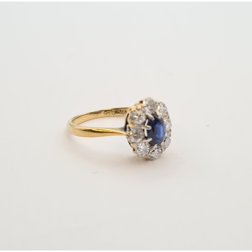 164 - A Sapphire and Diamond Cluster Ring claw-set oval-cut sapphire within a frame of eight brilliant-cut... 