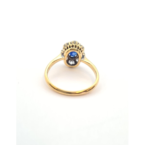 164 - A Sapphire and Diamond Cluster Ring claw-set oval-cut sapphire within a frame of eight brilliant-cut... 