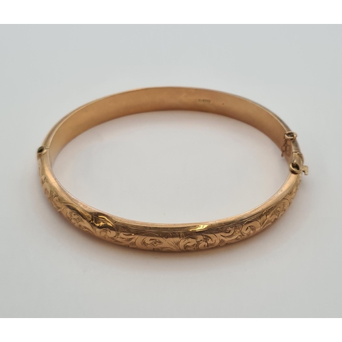 172 - A 9ct gold hinged Bangle with scroll engraving to front, approx 8.80gms