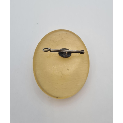 198 - A vintage oval celluloid Brooch depicting 'saucy blond' looking in the mirror, signed AC