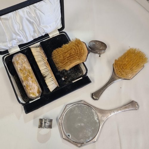 211 - A silver backed four piece Dressing Table Set an oval silver Trinket Box and a white metal Napkin Ri... 