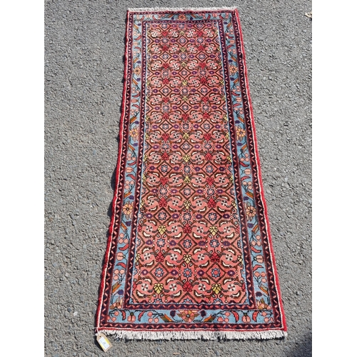 27 - A small Red Ground runner with multi-bordered leafage designs, 200 x 77cms