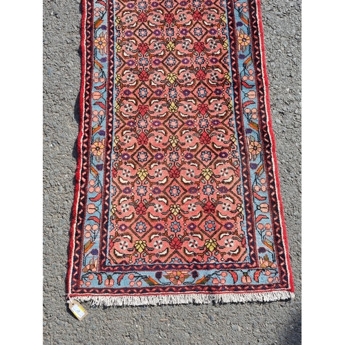 27 - A small Red Ground runner with multi-bordered leafage designs, 200 x 77cms