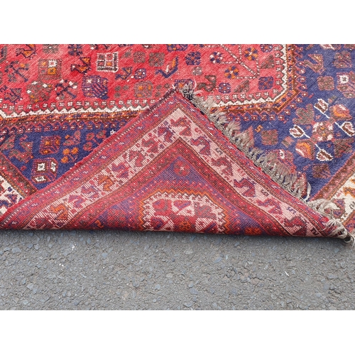 451 - A Persian style Carpet on red and blue ground, with multi borders with four octagonal motifs and lar... 