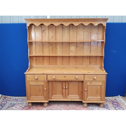 7 - A pine Dresser and Tack fitted three frieze drawers above four cupboard doors to base raised on bun ... 