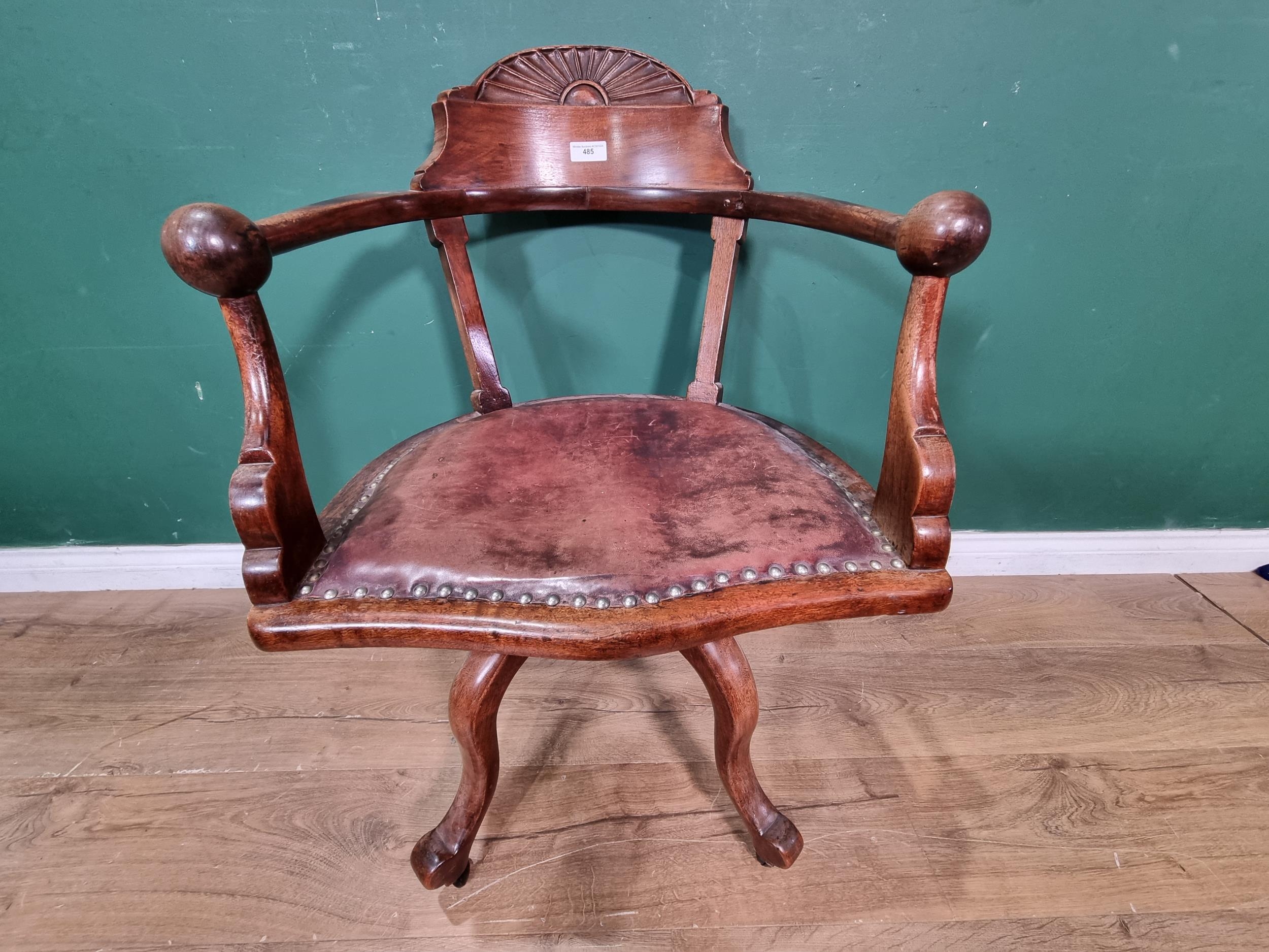 A mahogany swivel Office Chair with fan carved top rail and ball arm