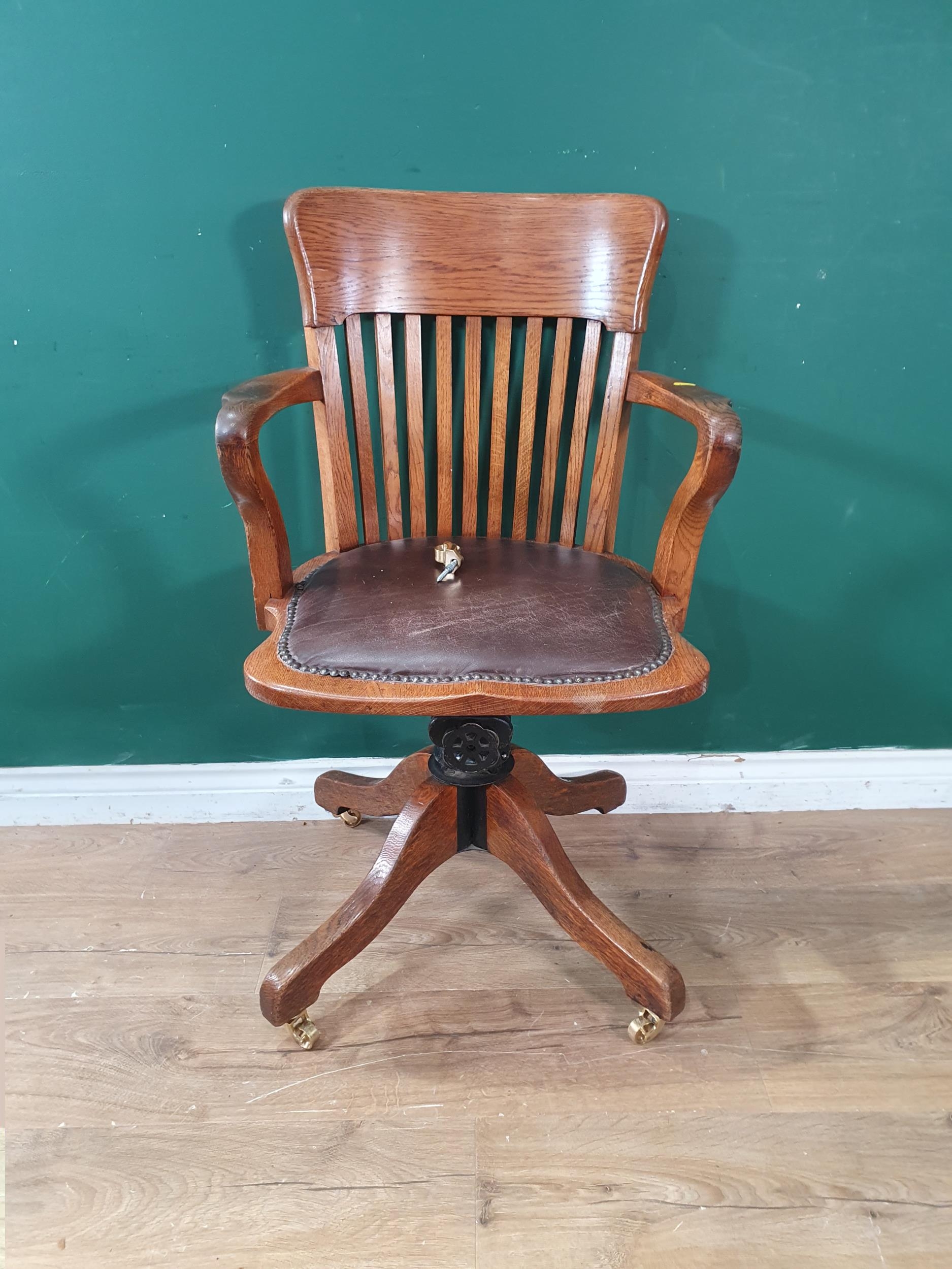 An oak framed Swivel Chair with leather style upholstered seat, raised