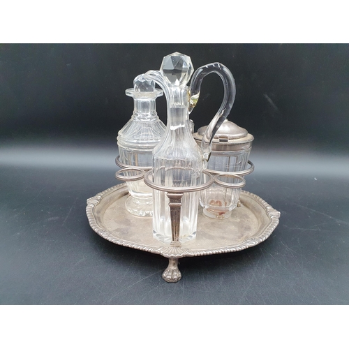 102 - A George III silver three bottle Cruet of kidney shape, leafage scroll handle, shell and gadroon rim... 