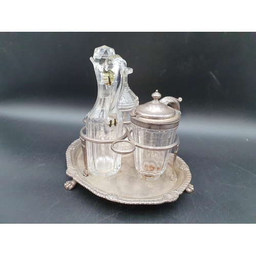 102 - A George III silver three bottle Cruet of kidney shape, leafage scroll handle, shell and gadroon rim... 