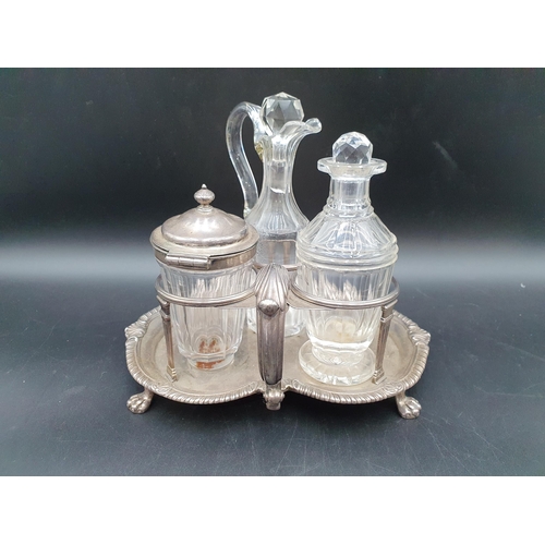 102 - A George III silver three bottle Cruet of kidney shape, leafage scroll handle, shell and gadroon rim... 