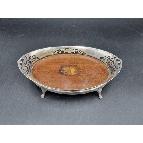 24 - An Edward VII silver oval Dish with pierced decoration, shaped feet, mahogany base with medallion in... 