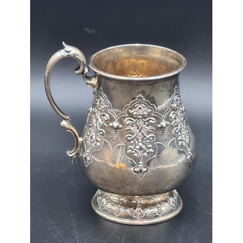 28 - A Victorian silver baluster Mug with strap work embossing and leafage scroll handle, London 1857, ma... 