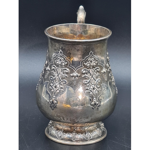 28 - A Victorian silver baluster Mug with strap work embossing and leafage scroll handle, London 1857, ma... 