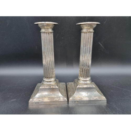 39 - A pair of George V silver Candlesticks with fluted columns on square bases, London 1914, 8in, Goldsm... 