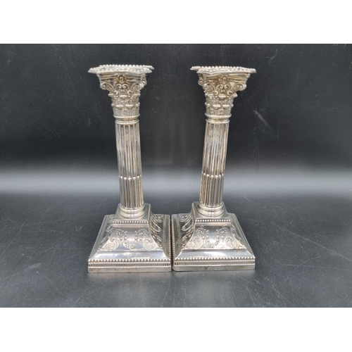 40 - A pair of Edward VII silver Candlesticks with fluted columns, corinthian capitals on beaded square b... 