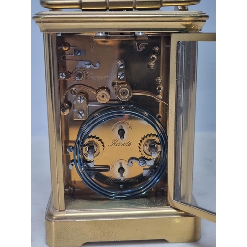 511 - A brass cased Carriage Clock with white enamel dial having subsidiary month dial and with repeater m... 