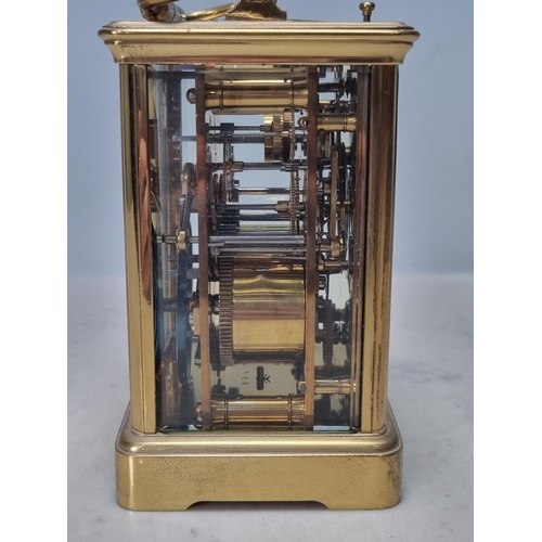 511 - A brass cased Carriage Clock with white enamel dial having subsidiary month dial and with repeater m... 