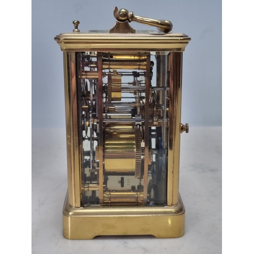 511 - A brass cased Carriage Clock with white enamel dial having subsidiary month dial and with repeater m... 