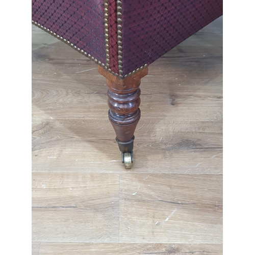 531 - A Georgian winged Armchair with burgundy studded upholstery raised on turned mahogany front supports... 