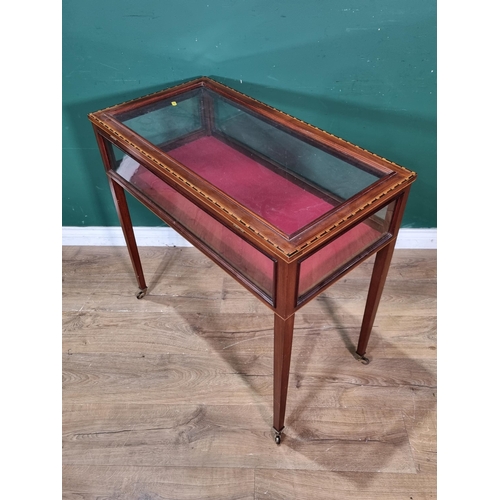 533 - An Edwardian inlaid mahogany table Display cabinet with glazed box top on tapering legs and casters,... 