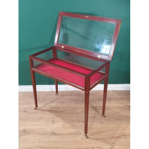 533 - An Edwardian inlaid mahogany table Display cabinet with glazed box top on tapering legs and casters,... 