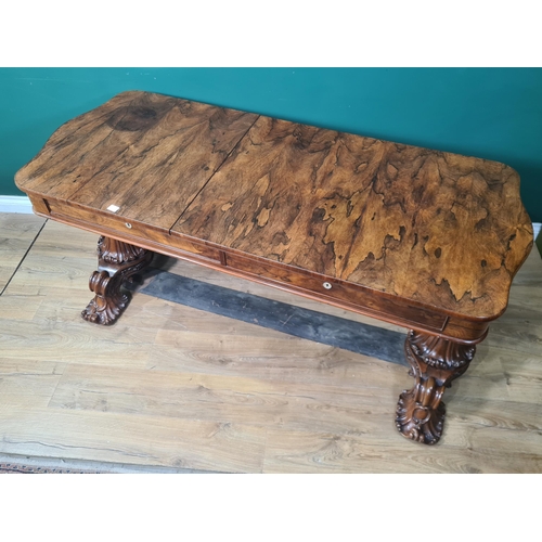 613 - A Victorian rosewood Library Table with shaped rectangular top fitted two drawers which open out to ... 