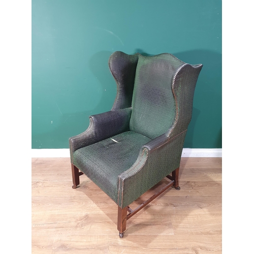 614 - A Georgian winged Armchair with humpback in dark green studded upholstery raised on square supports ... 