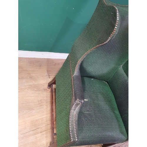 614 - A Georgian winged Armchair with humpback in dark green studded upholstery raised on square supports ... 