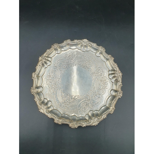 63 - A George III silver circular Salver with floral and scroll engraving, vacant cartouche, on three scr... 