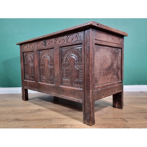 634 - A Mid 17th Century oak Coffer, the sunken three panel lid above carved arched frieze with three carv... 