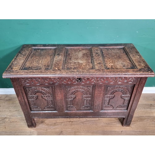 634 - A Mid 17th Century oak Coffer, the sunken three panel lid above carved arched frieze with three carv... 