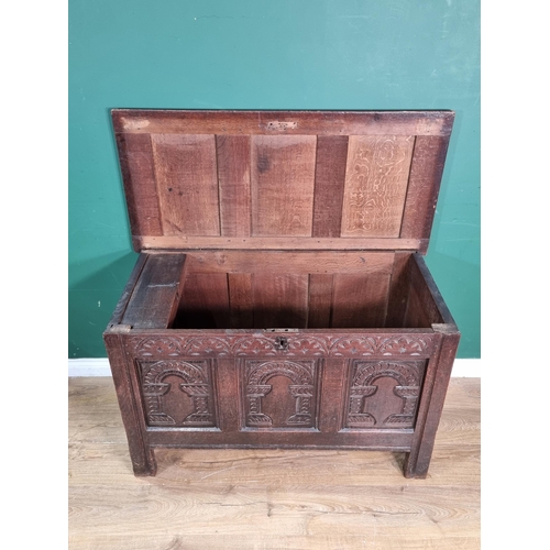 634 - A Mid 17th Century oak Coffer, the sunken three panel lid above carved arched frieze with three carv... 