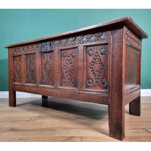 656 - An 18th Century oak Coffer with sunken four panel lid, the front with carved floral frieze above fiv... 