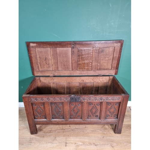 656 - An 18th Century oak Coffer with sunken four panel lid, the front with carved floral frieze above fiv... 