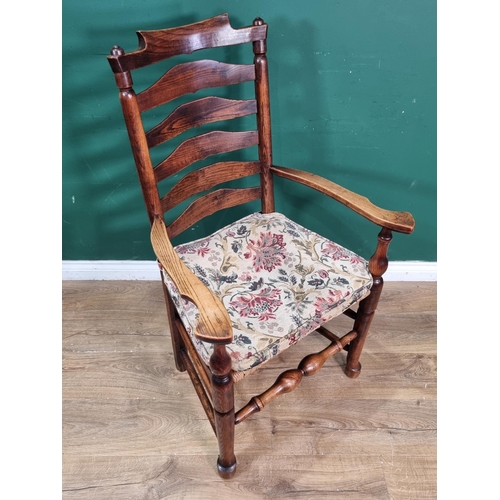 662 - A late 18th Century Ash ladder back Elbow Chair with shaped arms, rush seat and raised on turned tap... 