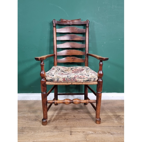 662 - A late 18th Century Ash ladder back Elbow Chair with shaped arms, rush seat and raised on turned tap... 