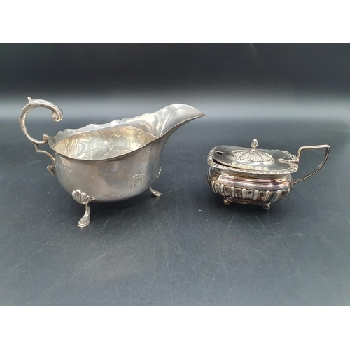 71 - An Edward VII silver Sauce Boat with leafage scroll handle on three hoof feet, Birmingham 1904, and ... 