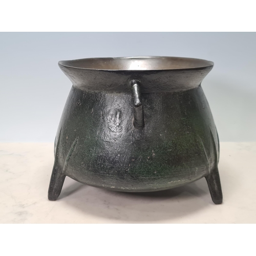 784 - A 17th Century bronze Cauldron with flared rim, angular lugged handles, raised on ribbed tripod supp... 