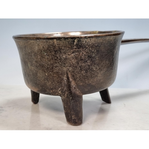 794 - An antique bronze Skillet on wedge shaped supports, the handle bearing the name 