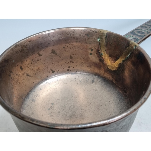 794 - An antique bronze Skillet on wedge shaped supports, the handle bearing the name 