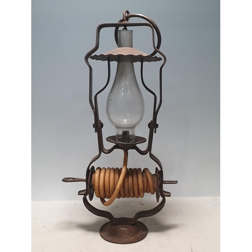 803 - A wrought iron Wax Jack Lamp with swing handle, with glass flue on circular base, 14in H