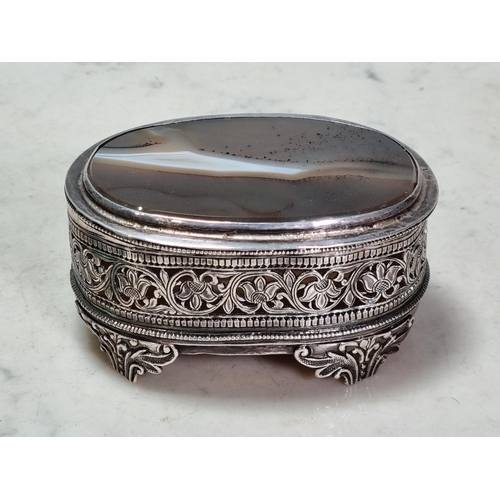 846 - A Mughal hammered silver Indian oval Box, with agate lid and base, with pierced floral designs and r... 