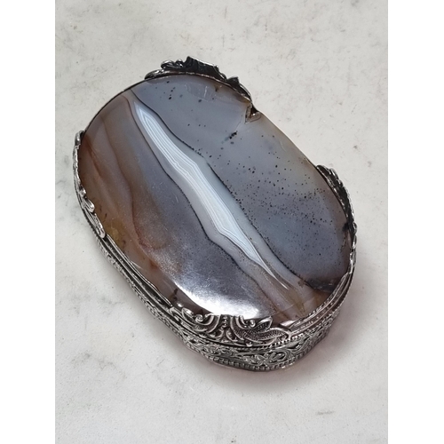 846 - A Mughal hammered silver Indian oval Box, with agate lid and base, with pierced floral designs and r... 