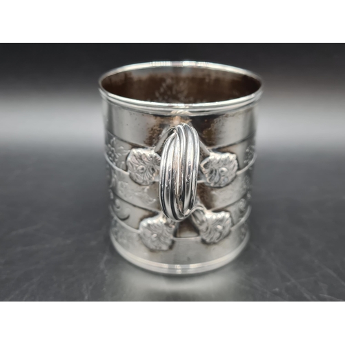 87 - A Victorian silver Mug with floral and scroll engraving, presentation inscription, cross-over handle... 