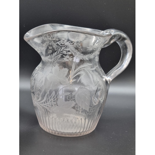 880 - An antique glass Jug engraved monogram, fruiting vine, leafage and swag designs, ribbed base, 6 1/4i... 