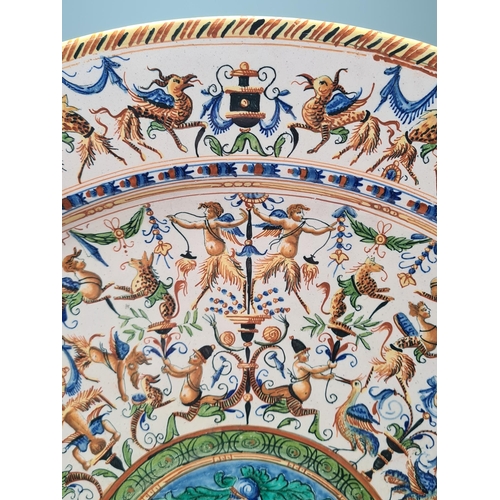 904 - A Continental Miolica Charger decorated with borders of mythical beasts, the centre with circular pa... 